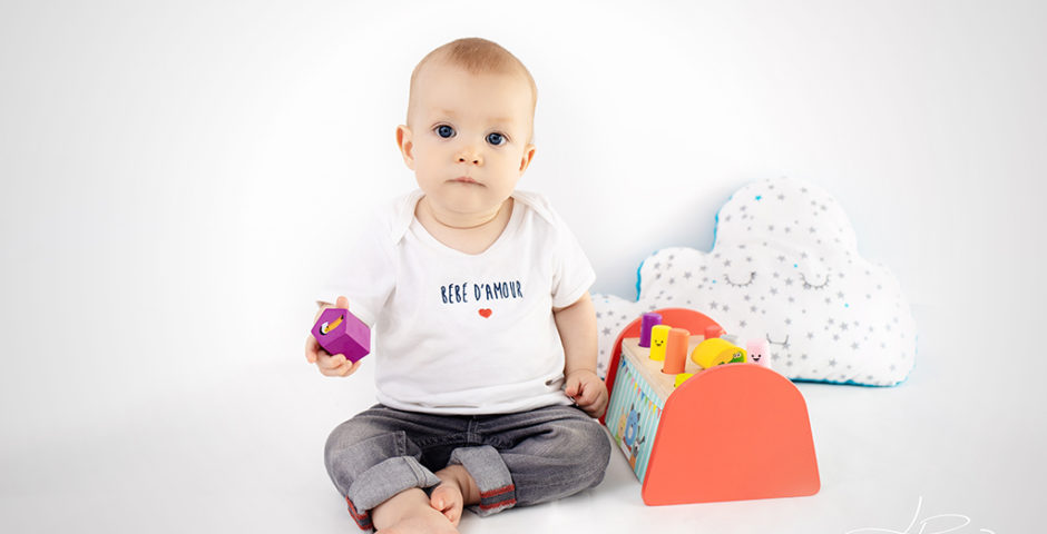 lifestyle bébé grandit 9 mois gars fond blanc jouet bois